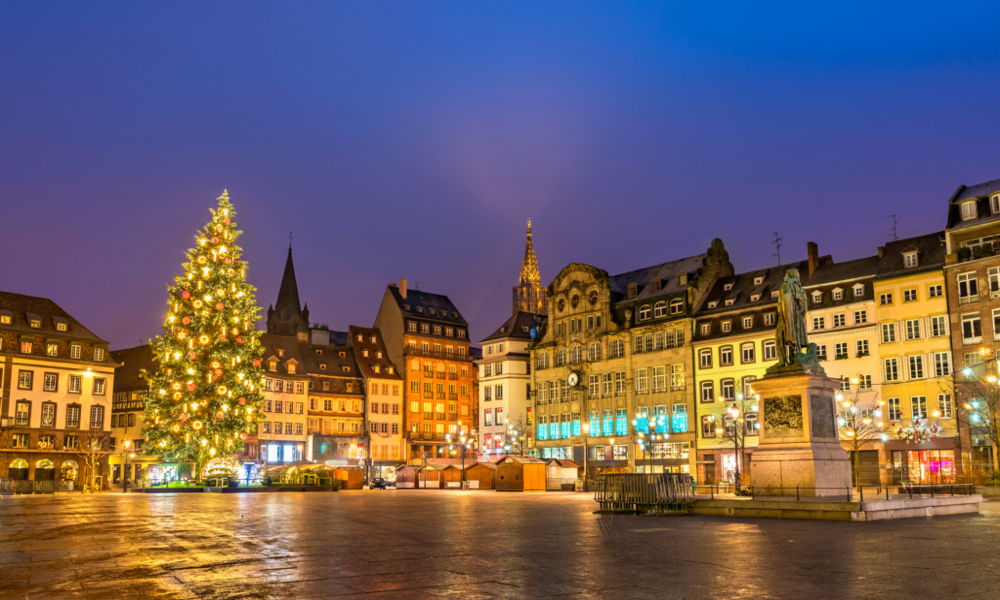 Der Marktplatz von Straßburg am Abend mit einem großen schön geschmückten Weihnachtsbaum.